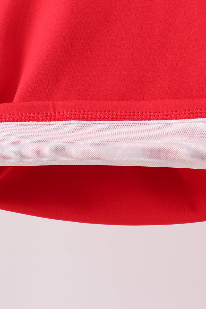Close-up of a red and white sports outfit with a visible brand logo.
