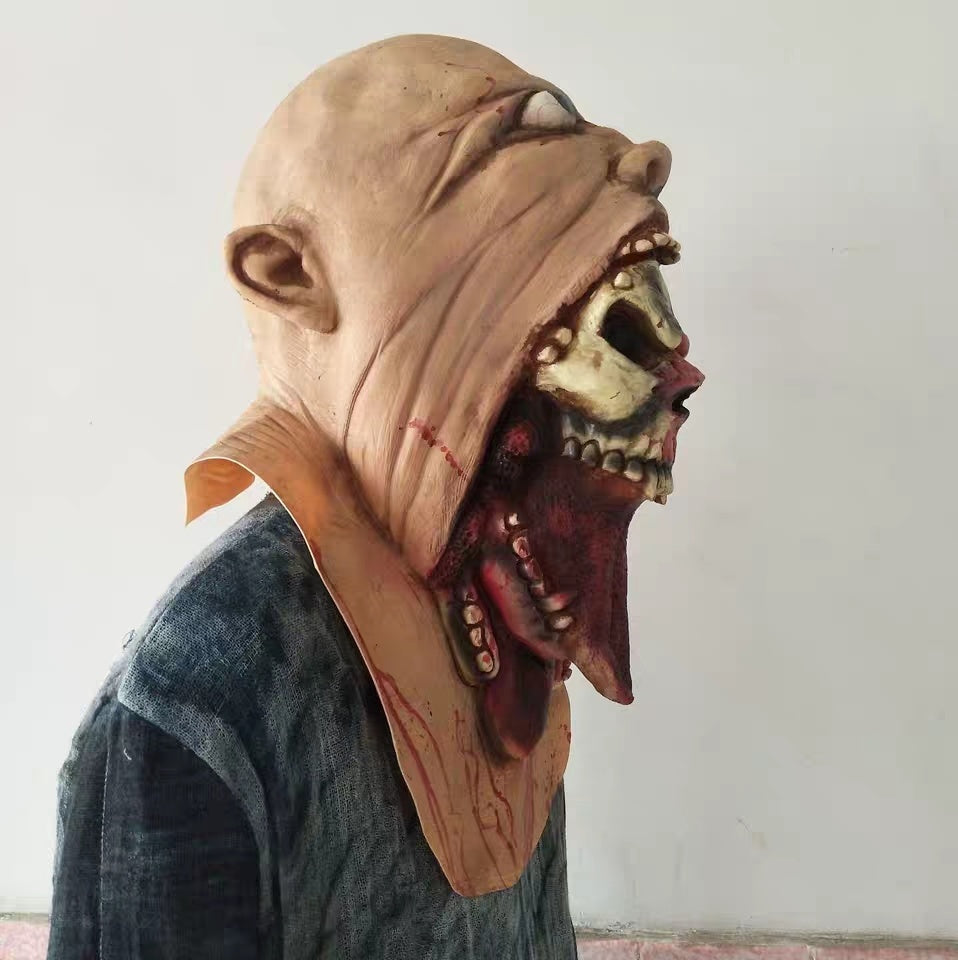 Person wearing a detailed mask with a skull design on a plain background