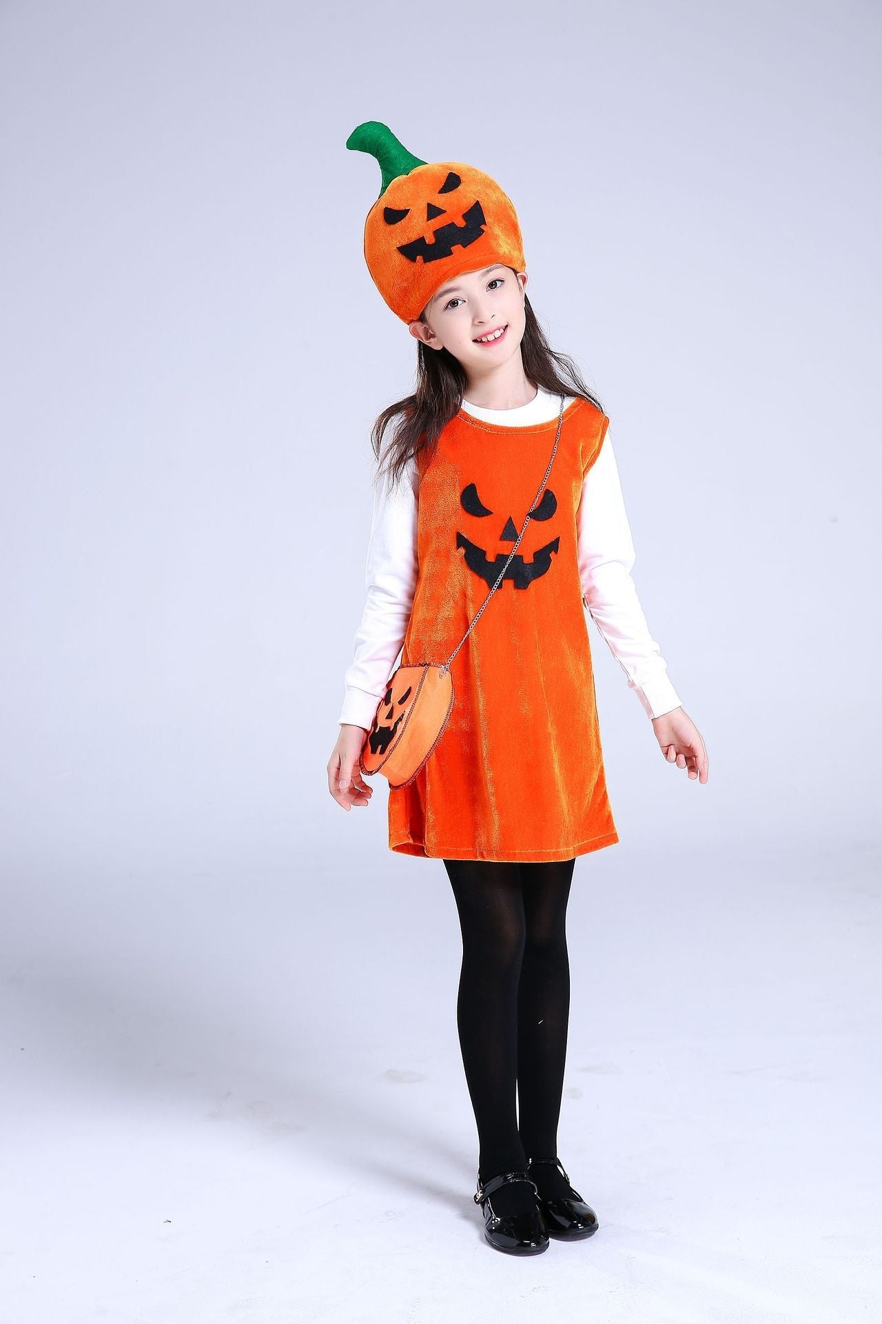 Child wearing an orange Halloween costume with a pumpkin hat and dress on a white background