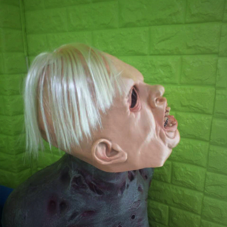 Mannequin head with blonde hair against a green textured wall