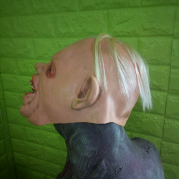 Mannequin head with blonde hair against a green textured wall