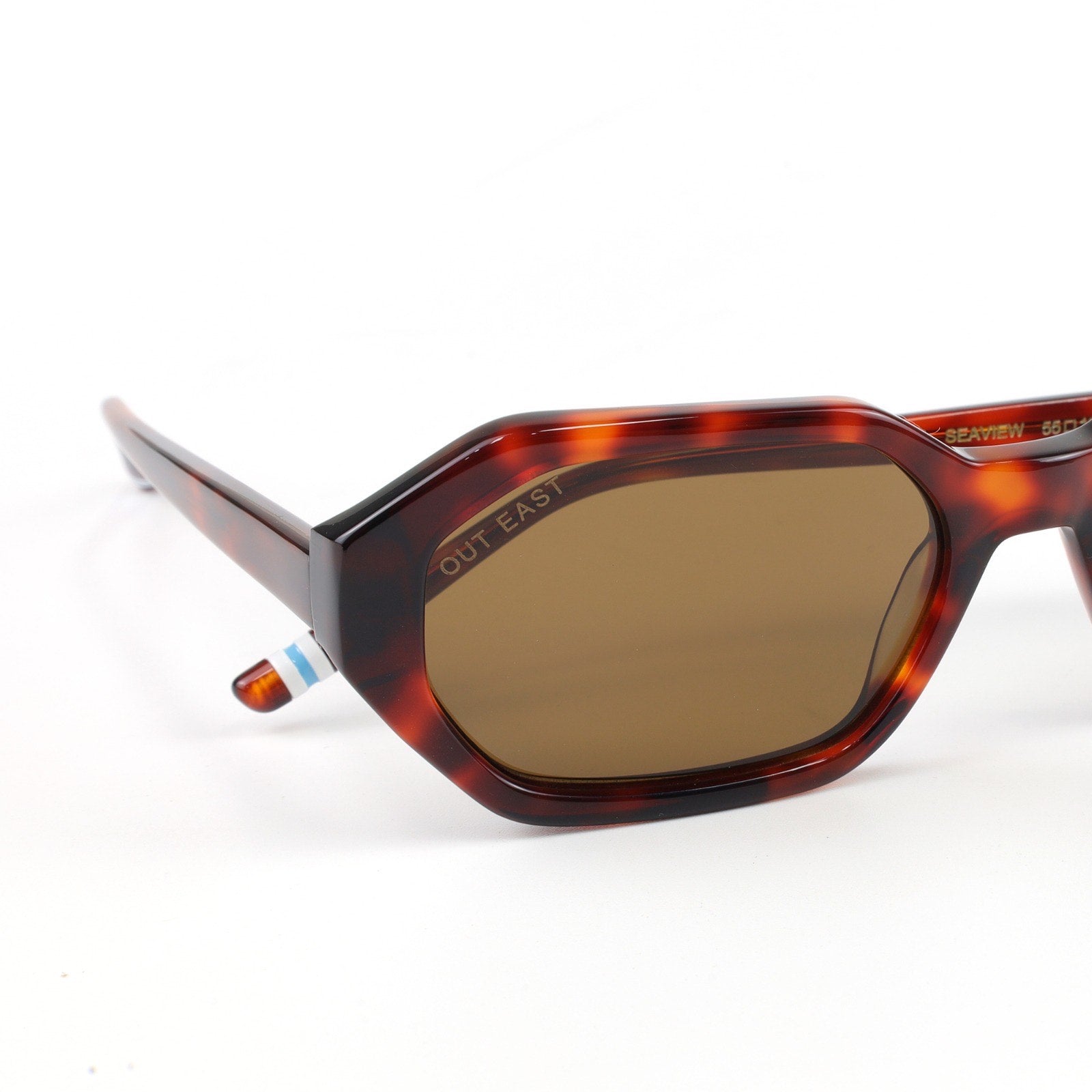 Sunglasses with tortoiseshell frame and brown lenses on a white background