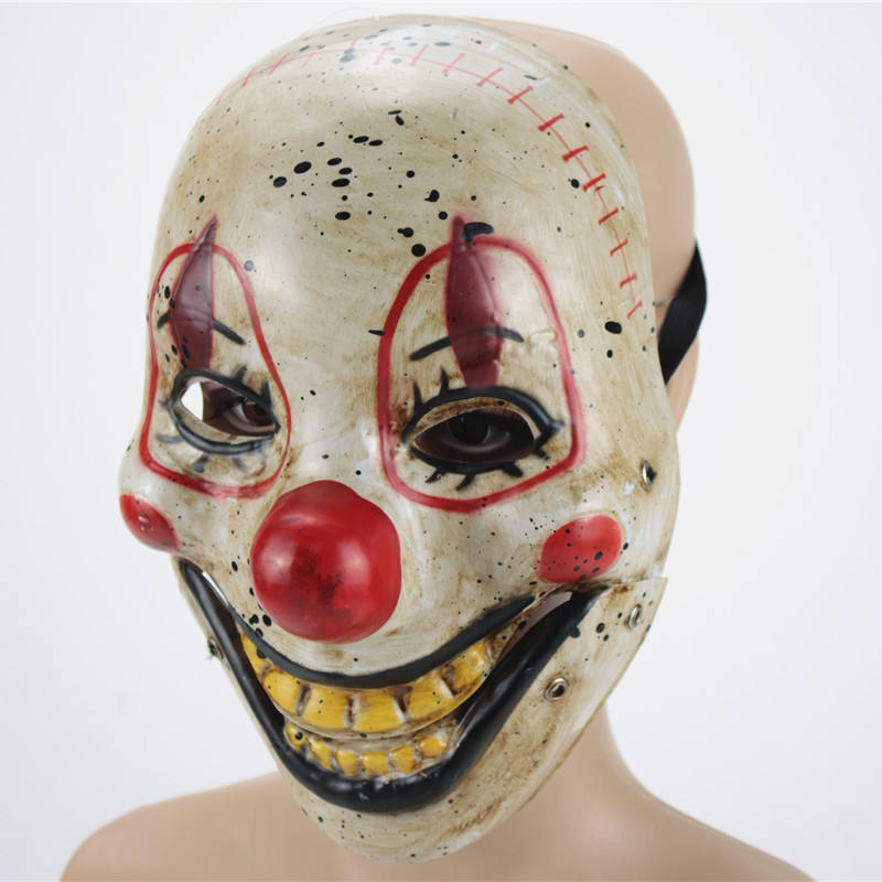 Creepy clown mask with red nose and yellow teeth on a mannequin head against a white background