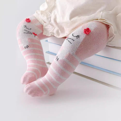 Baby legs wearing pink striped socks with floral designs on a light background