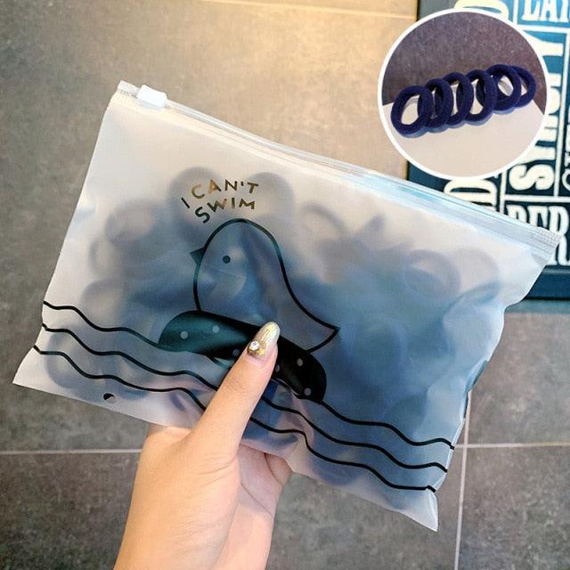Clear plastic bag with a duck design and text 'I Can't Swim' held by a hand.
