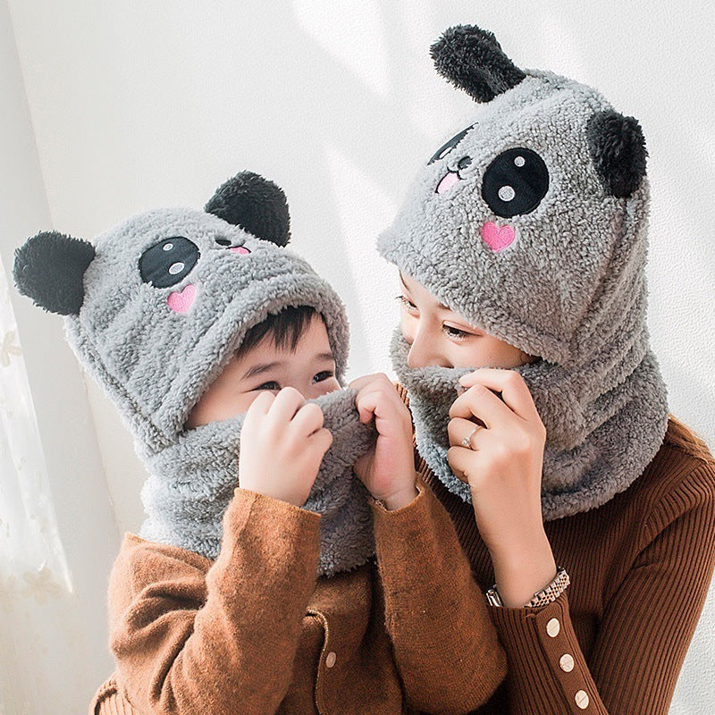Two children wearing gray panda hats with black ears and pink cheeks on a white background.