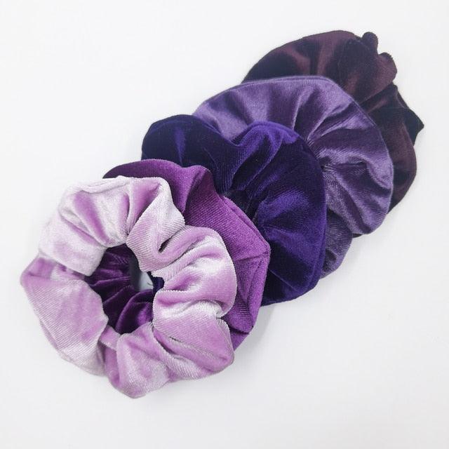 Set of purple and pink scrunchies on a white background