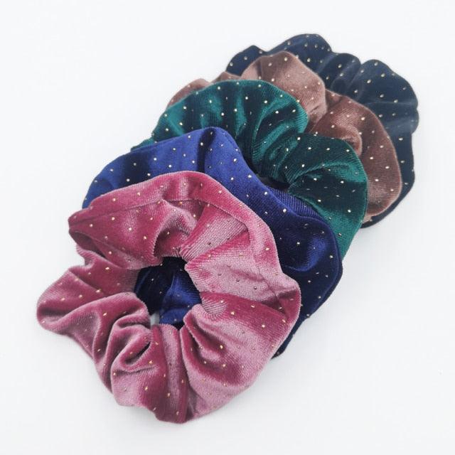 Set of colorful velvet scrunchies with polka dot pattern on a white background