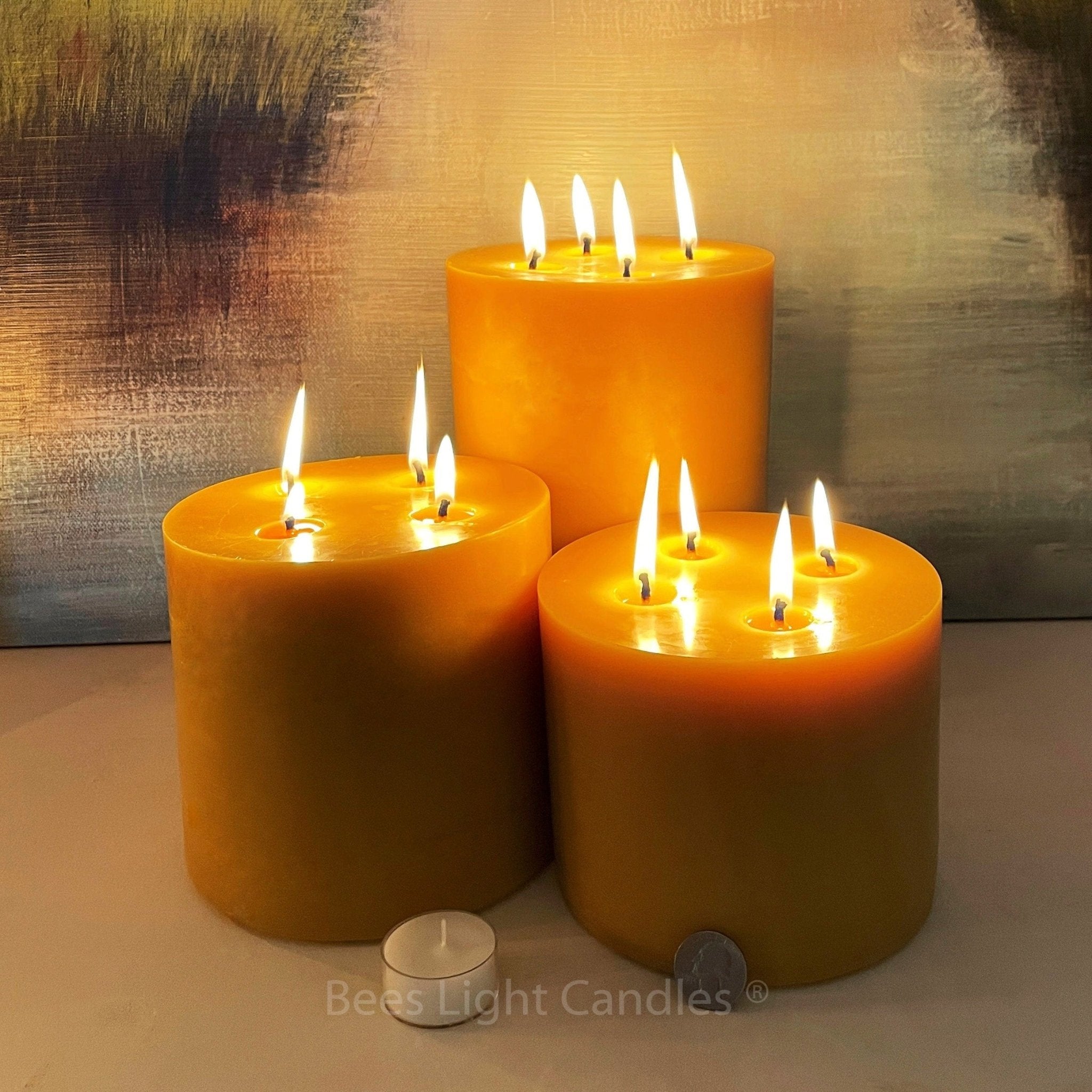 Three lit candles on a neutral surface with a soft background