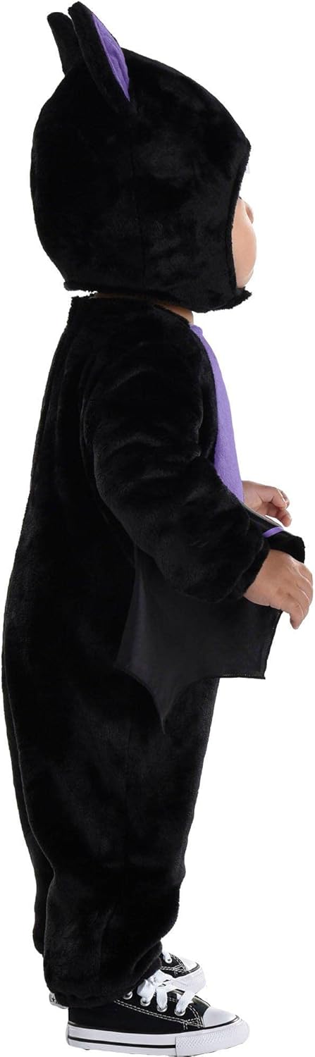 Child wearing a black cat-themed costume with ears on a white background