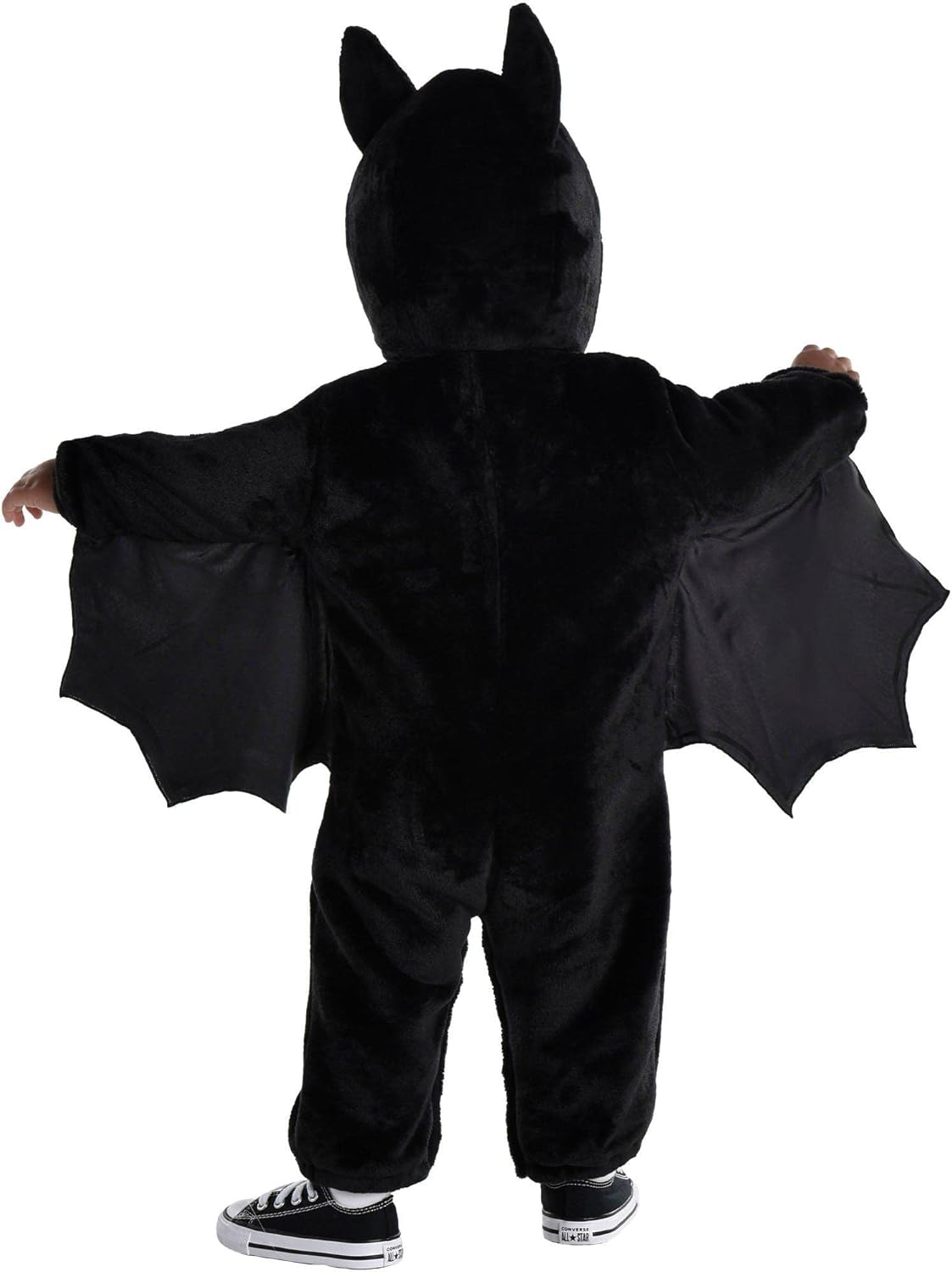 Child wearing a black bat costume with wings on a white background