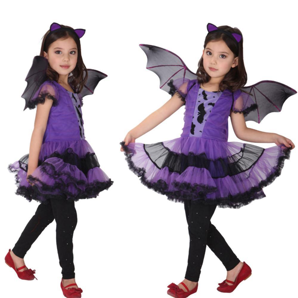Child wearing a purple and black bat costume with wings on a white background