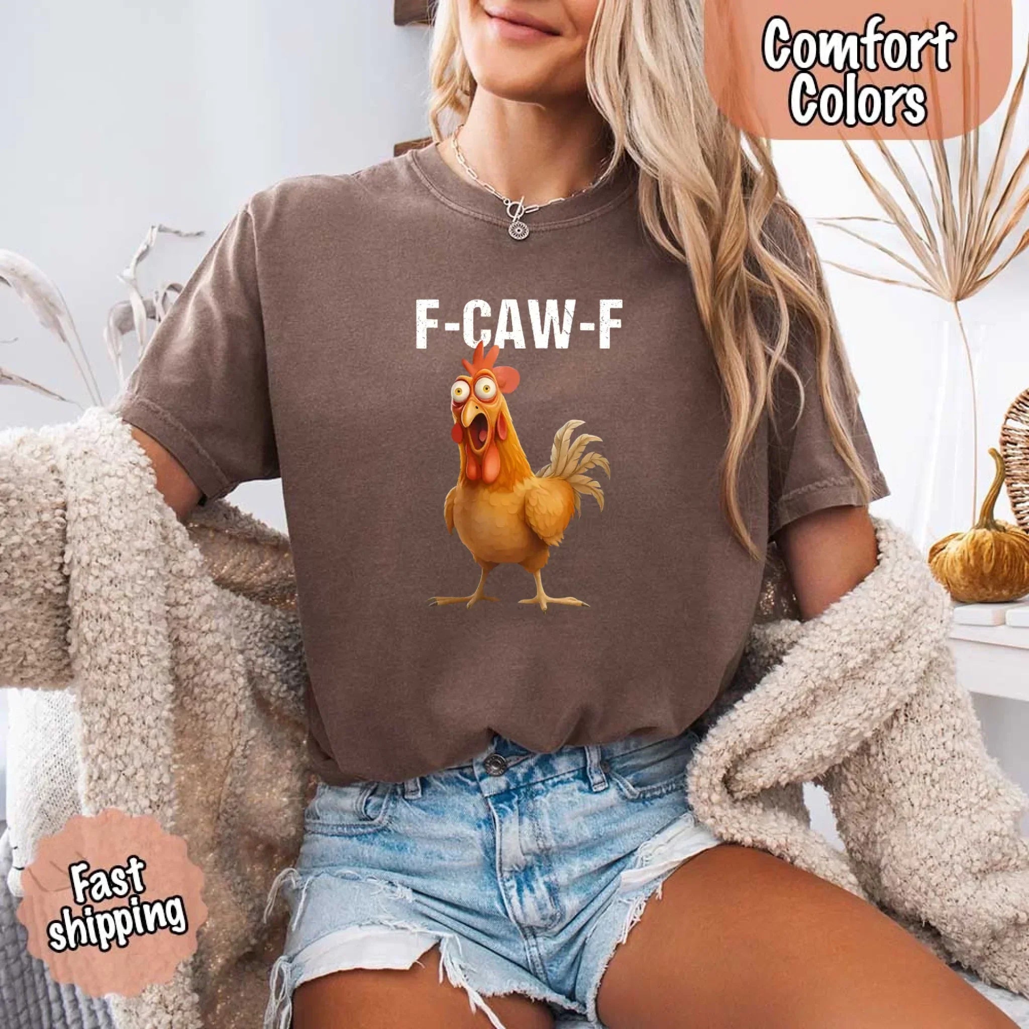 Person wearing a brown t-shirt with a cartoon chicken graphic and text, sitting on a couch.