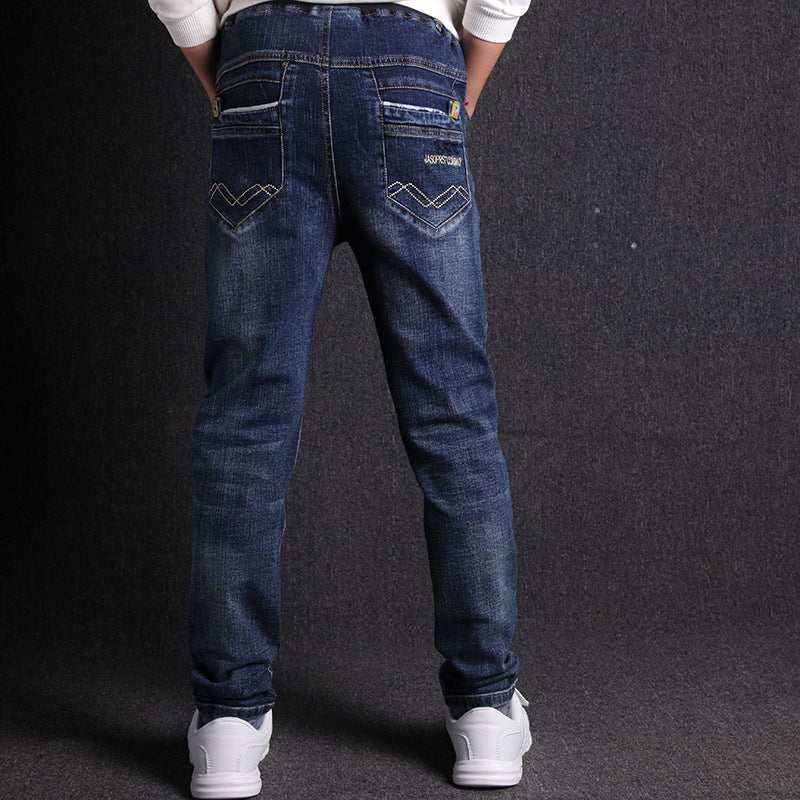 Person wearing blue jeans with a dark background