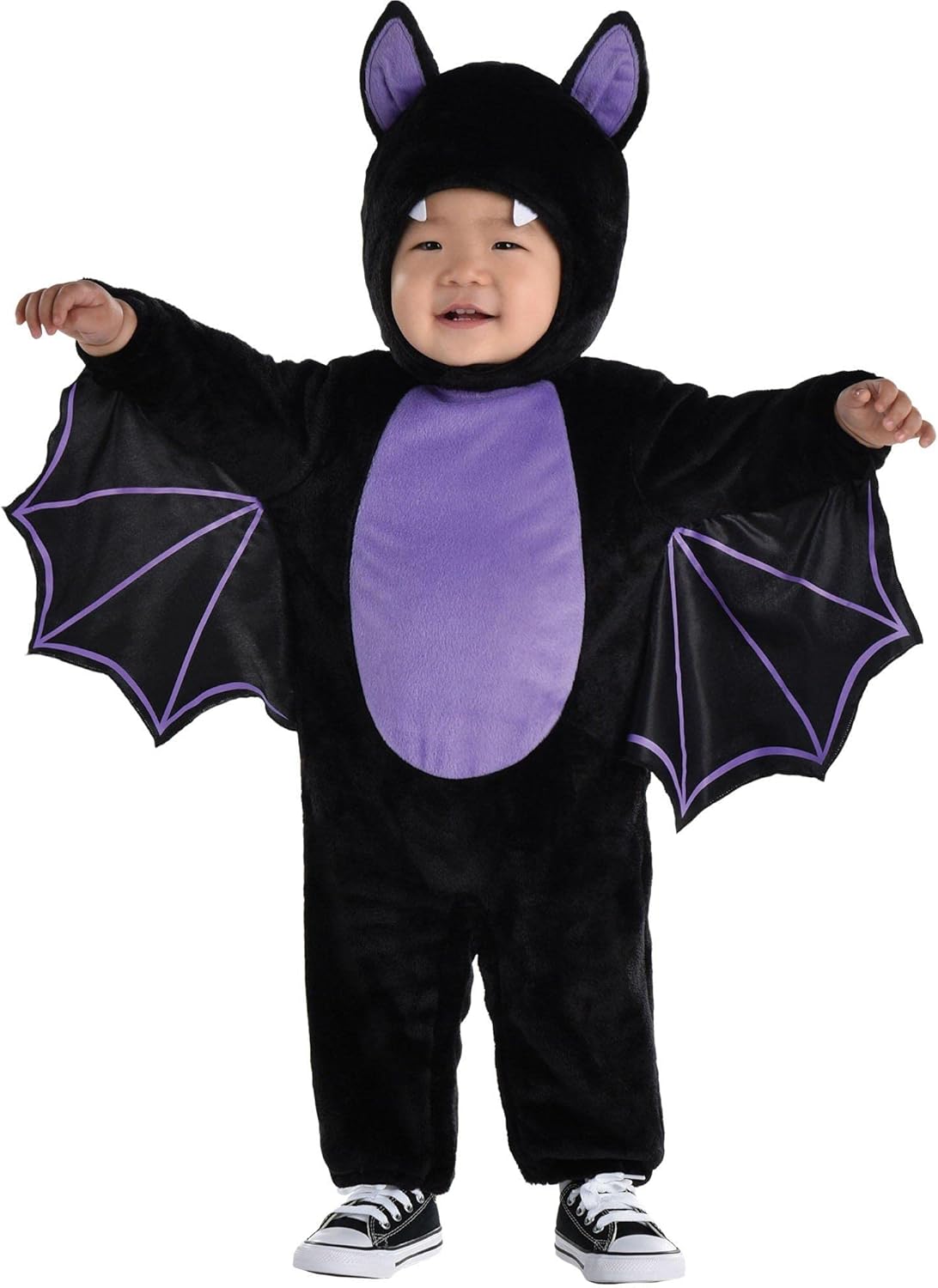 Child wearing a black and purple bat costume on a white background