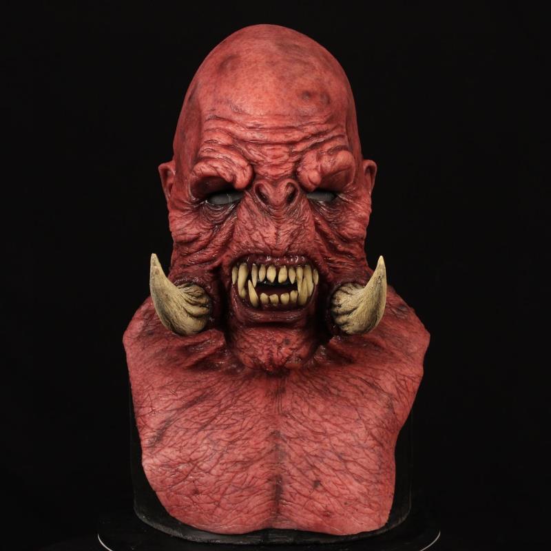 Red creature head with tusks on a black background