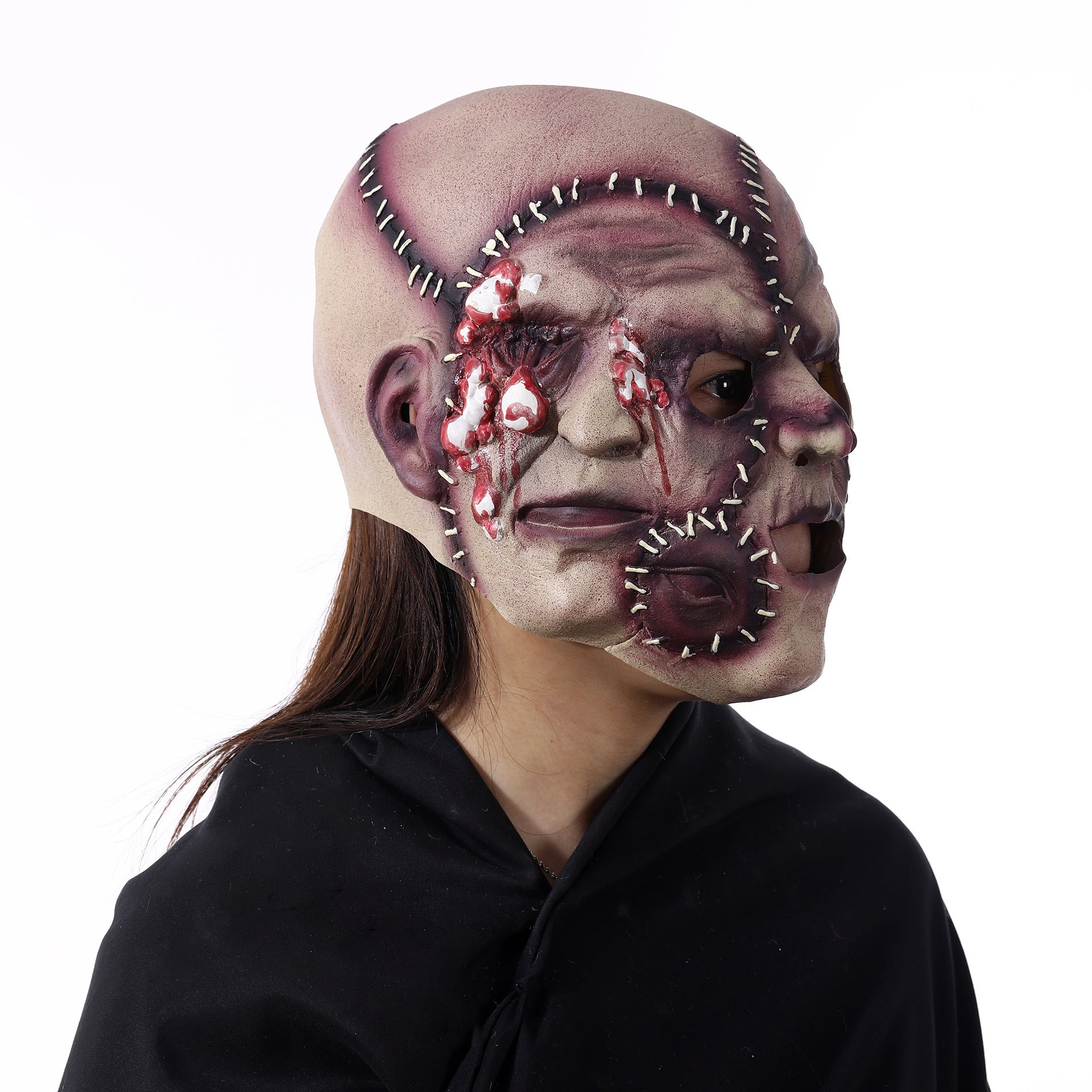 Person wearing a horror-themed mask with visible stitches and blood on a white background