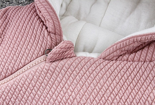 Close-up of a pink textured blanket on a white surface