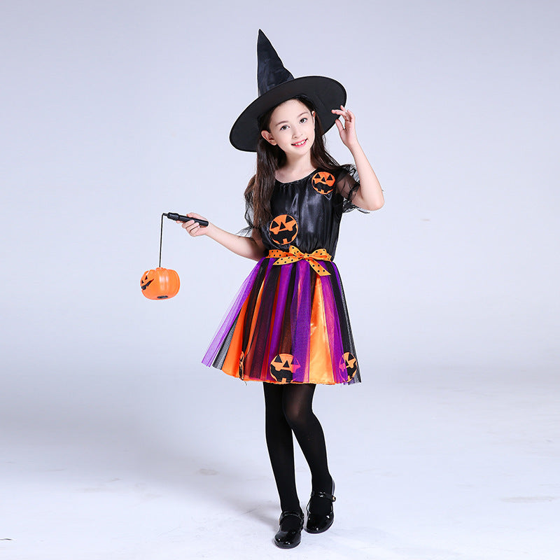 Child wearing a Halloween-themed dress with pumpkins and a witch hat on a white background