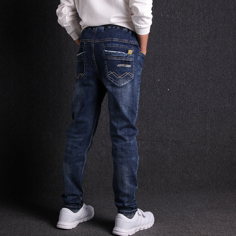 Person wearing blue jeans with a visible brand logo on a dark background