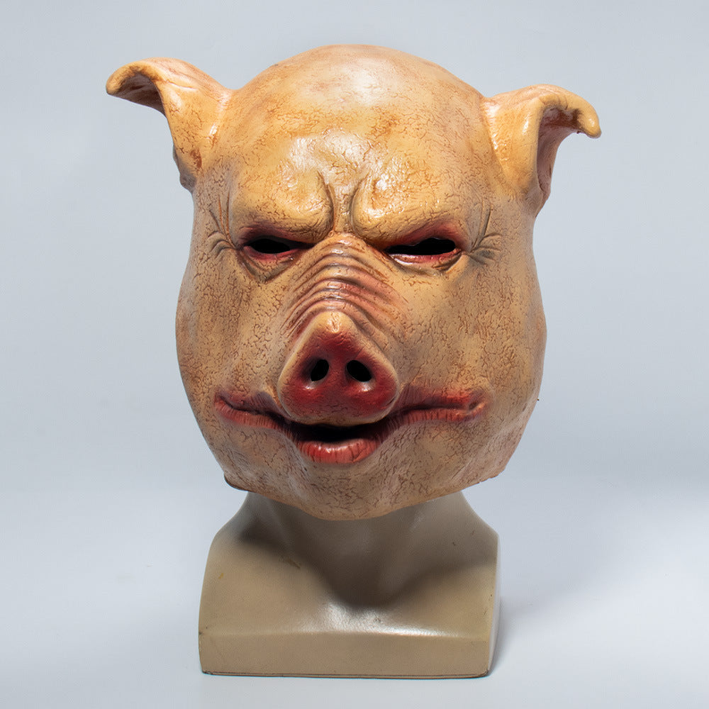 A realistic pig mask with a mounted base, photographed against a neutral light gray background.
