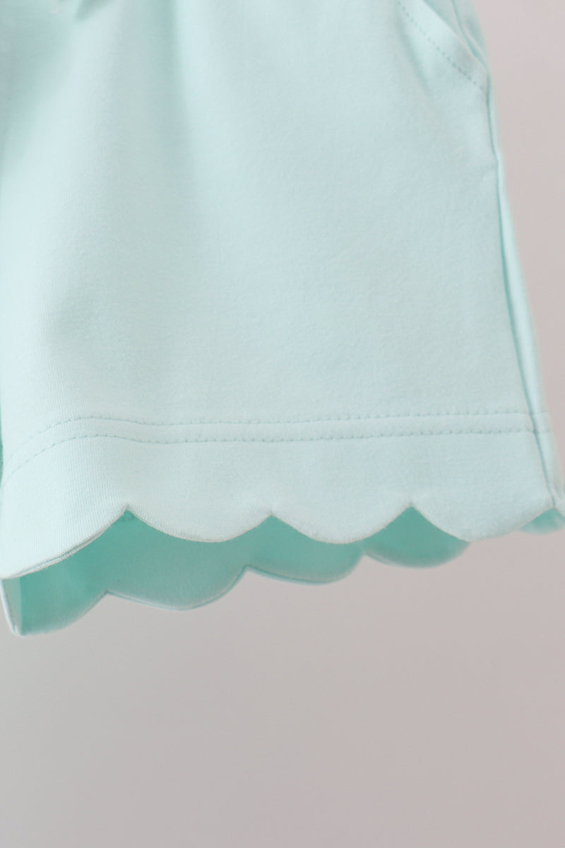 Light blue fabric with scalloped edge on a pink background