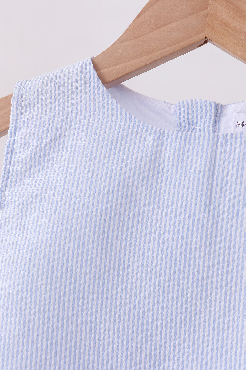 Light blue and white striped fabric on a wooden hanger against a light background