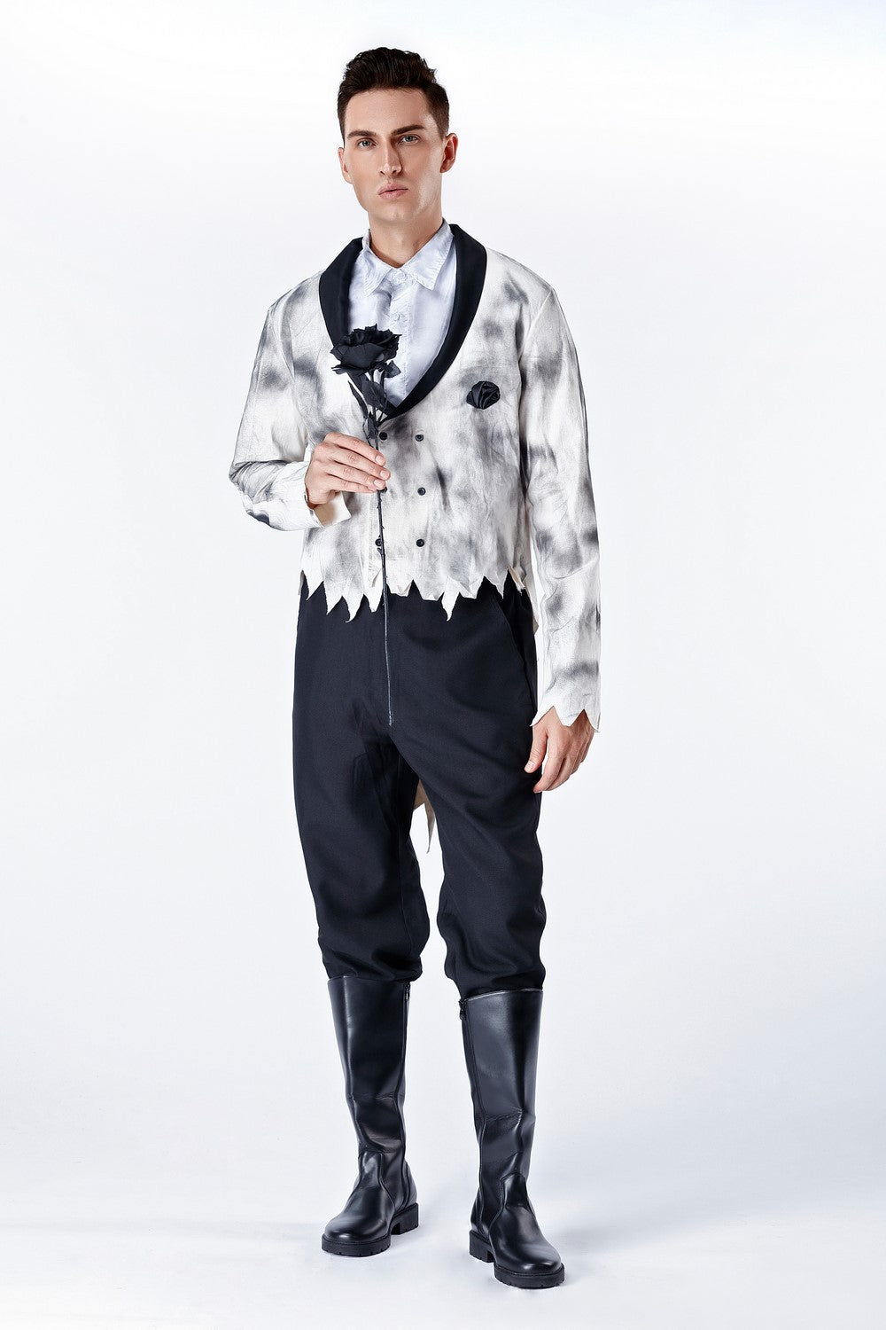 Man wearing a stylish outfit with a patterned shirt, black vest, and pants on a white background
