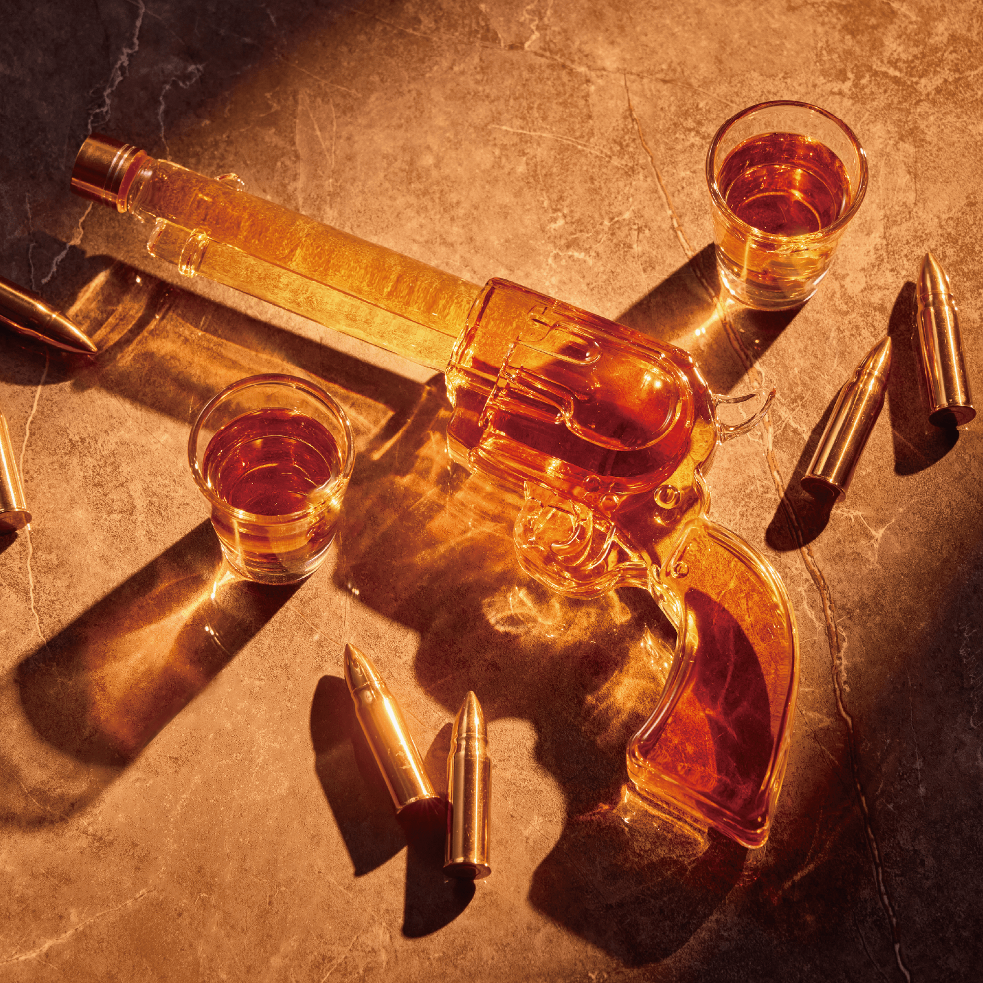 Decorative bottle shaped like a revolver with two glasses of amber liquid on a textured surface.