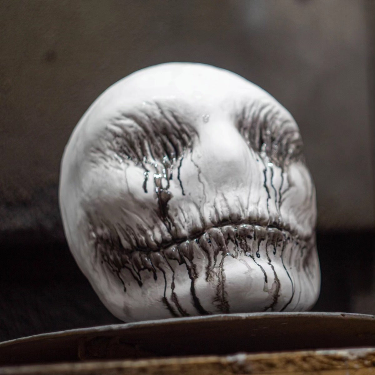 Close-up of a stone with facial features carved into it against a dark background