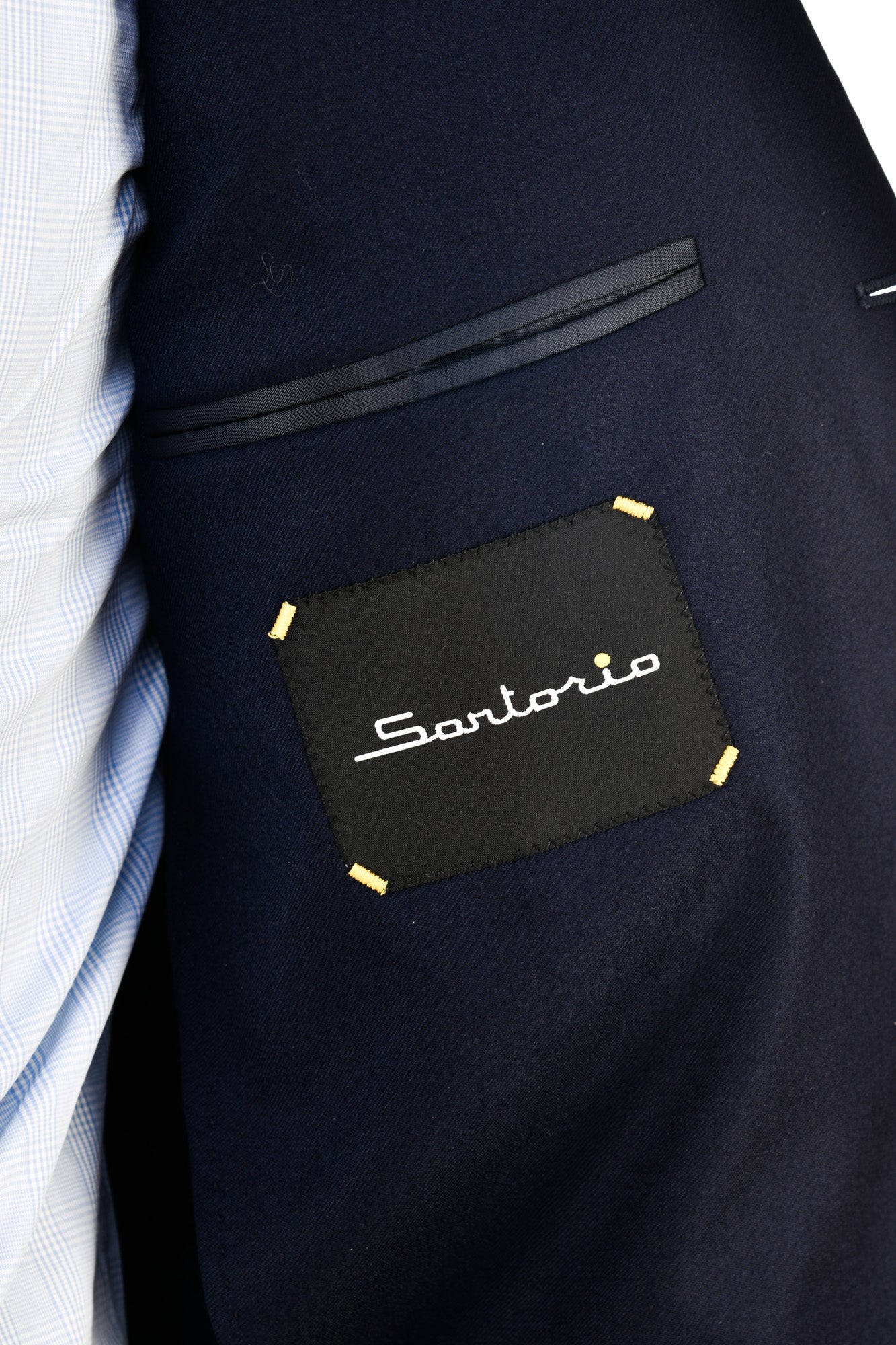 Navy suit jacket with 'Santorio' logo patch on a white shirt background