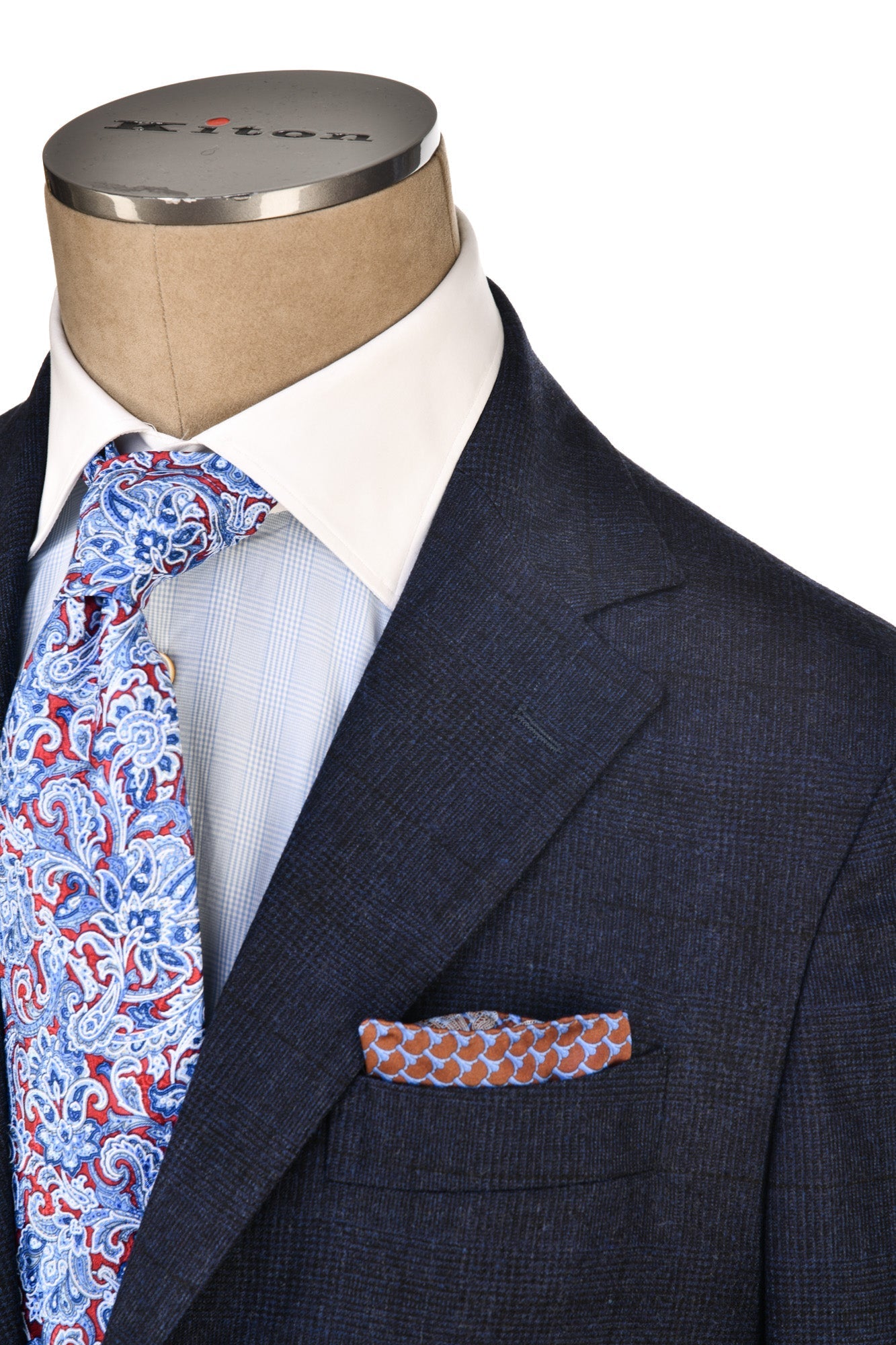Mannequin wearing a navy suit with a patterned tie and pocket square on a white background