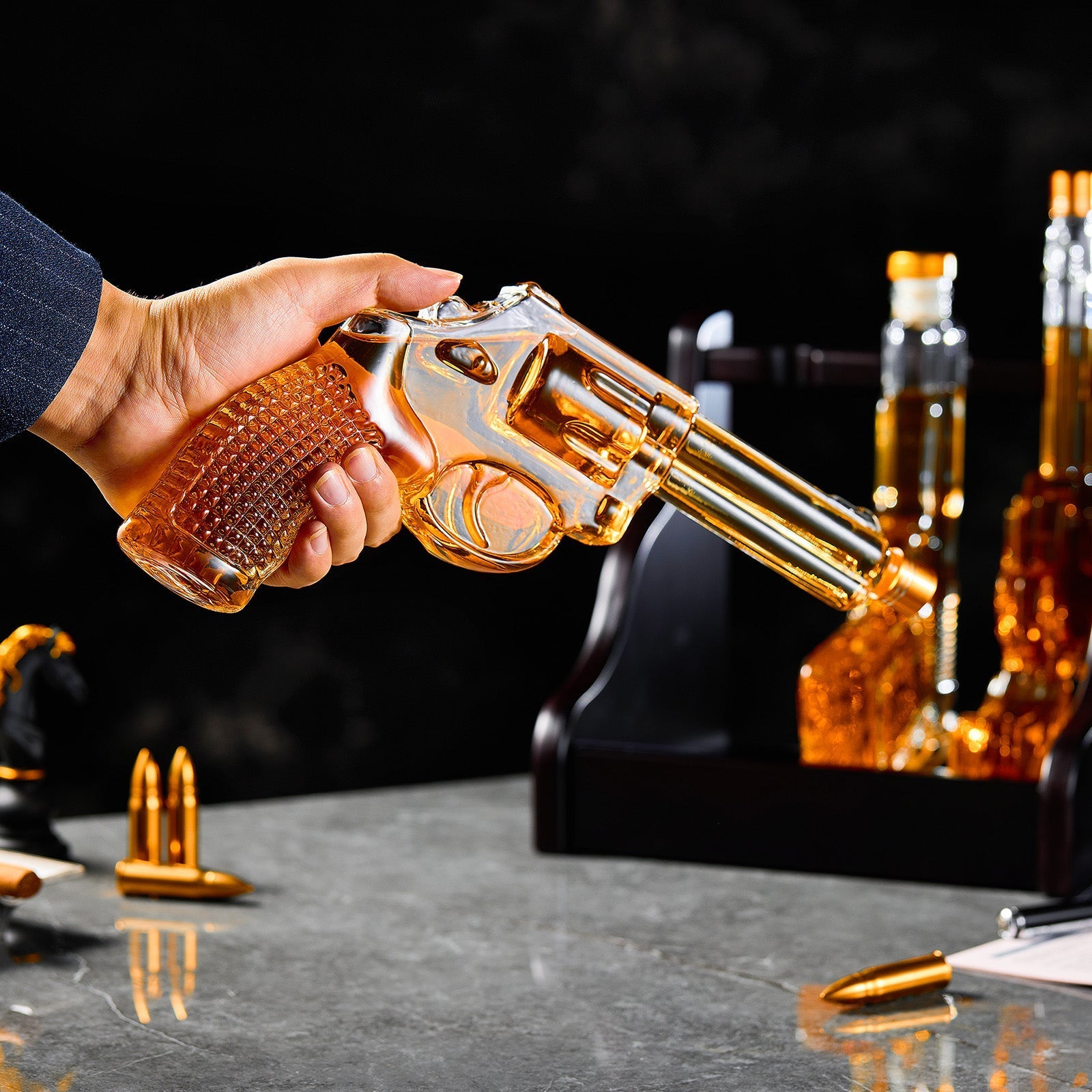 Gold revolver being held over a table with bottles and bullets in the background