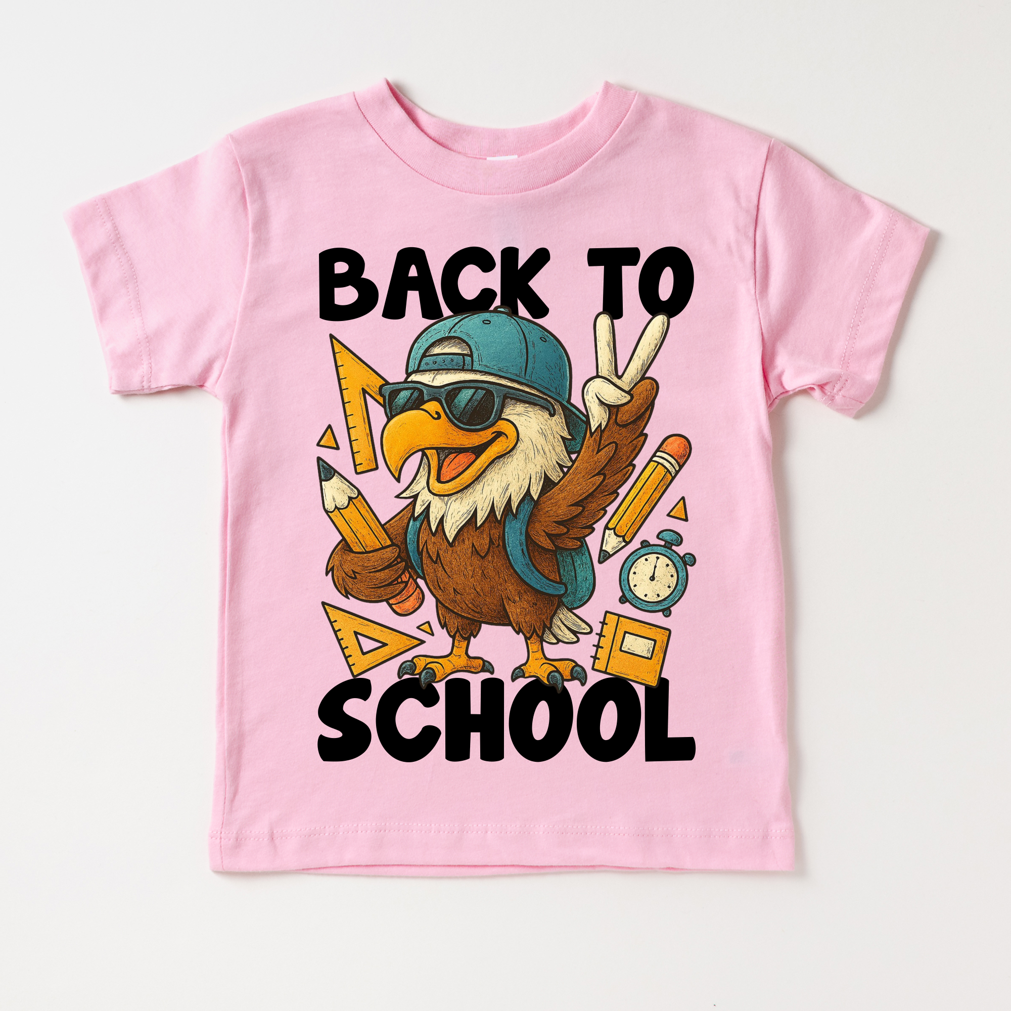 Pink t-shirt with an eagle graphic and 'Back to School' text on a white background