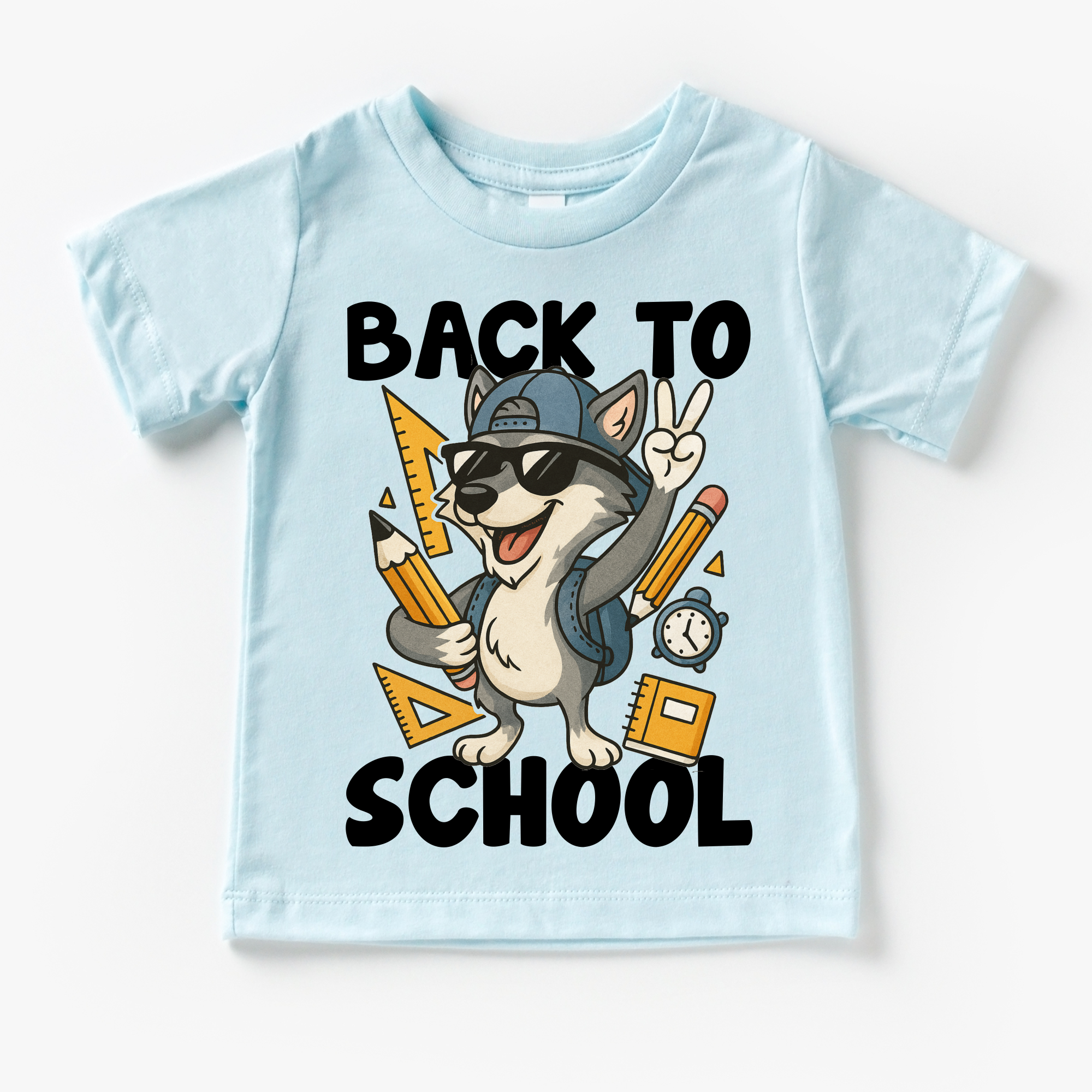 Light blue t-shirt with a cartoon wolf wearing sunglasses and a cap, holding pencils and a ruler, with 'Back to School' text on a white background.