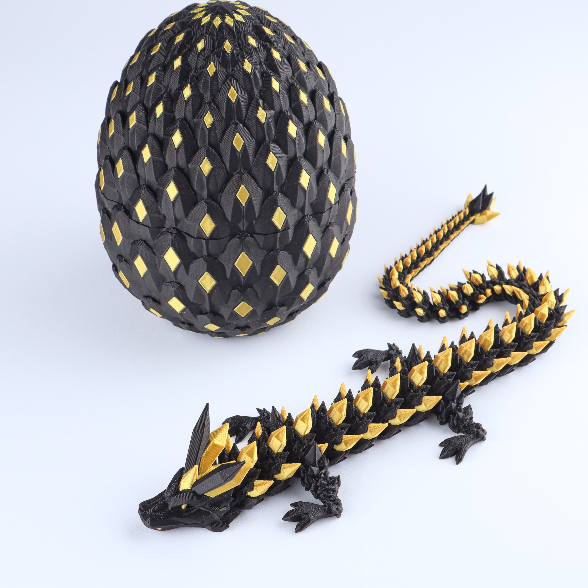 Black and gold dragon egg with a dragon model on a white background
