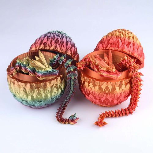 Two colorful dragon-shaped containers with open lids on a white background