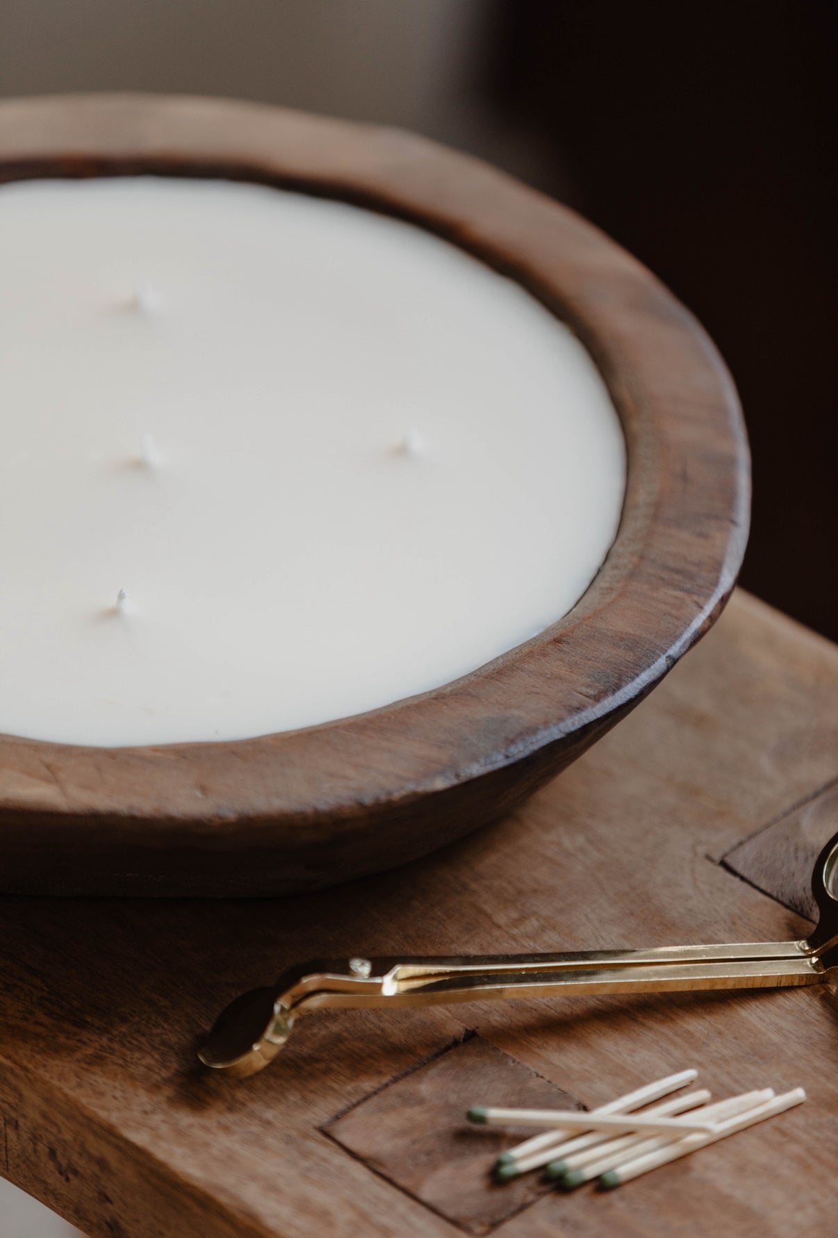 Wooden bowl with a candle and matches on a wooden surface