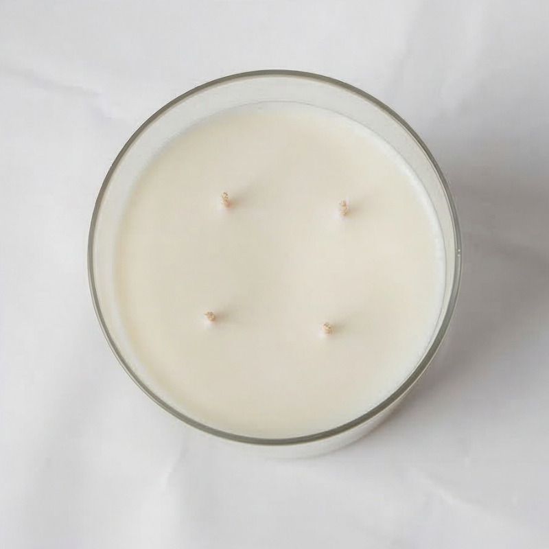 White candle in a glass jar on a white background