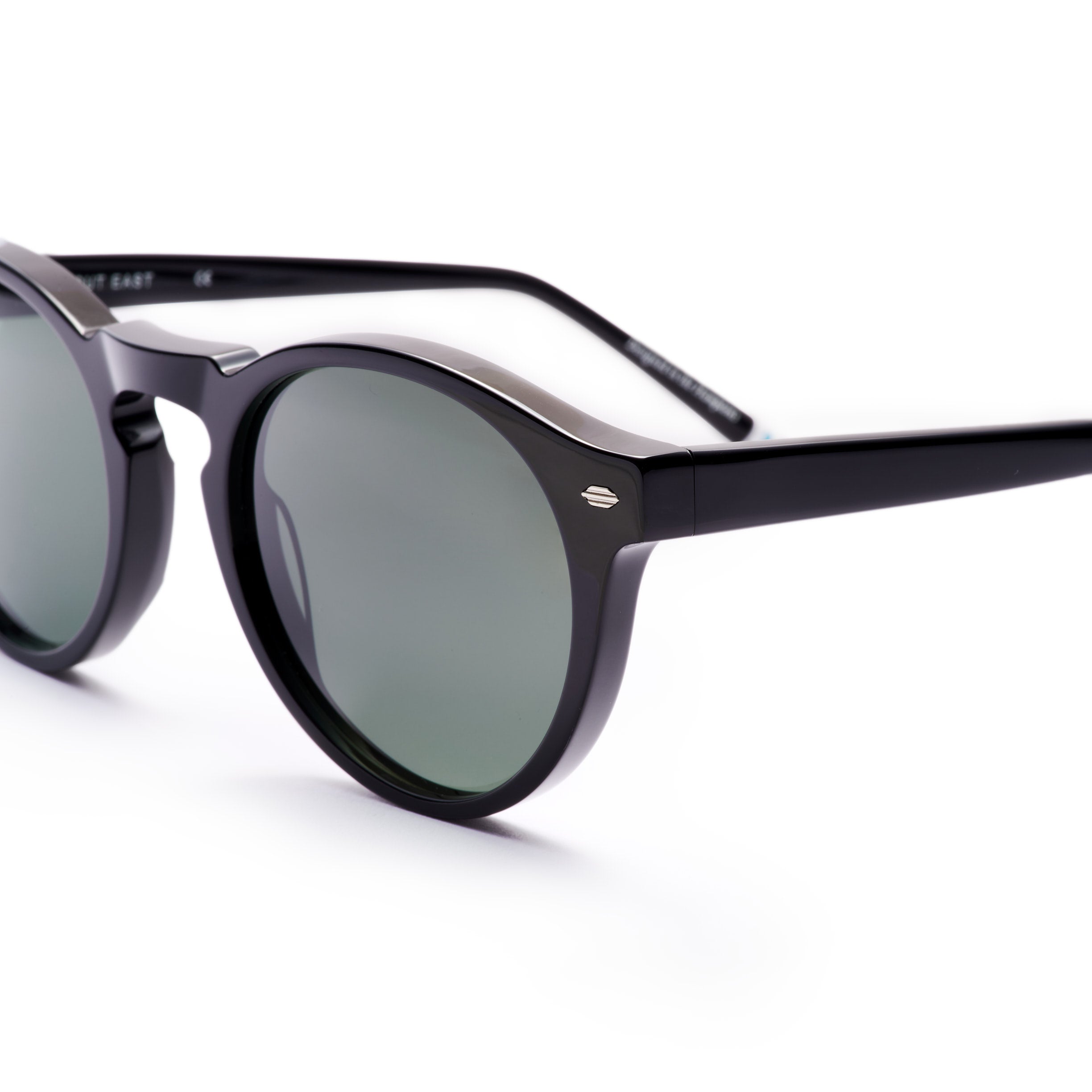 Black sunglasses with green lenses on a white background