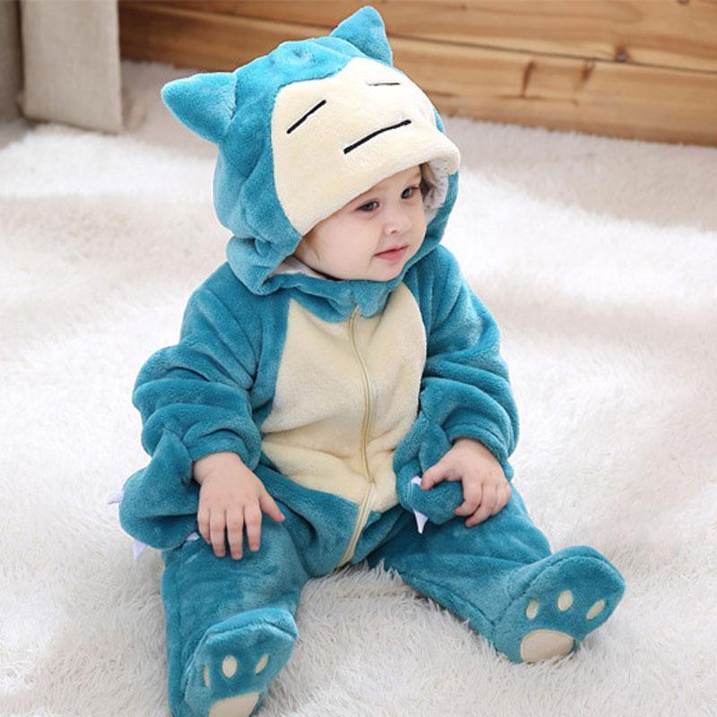Child wearing a blue and cream cartoon character onesie on a white carpet.