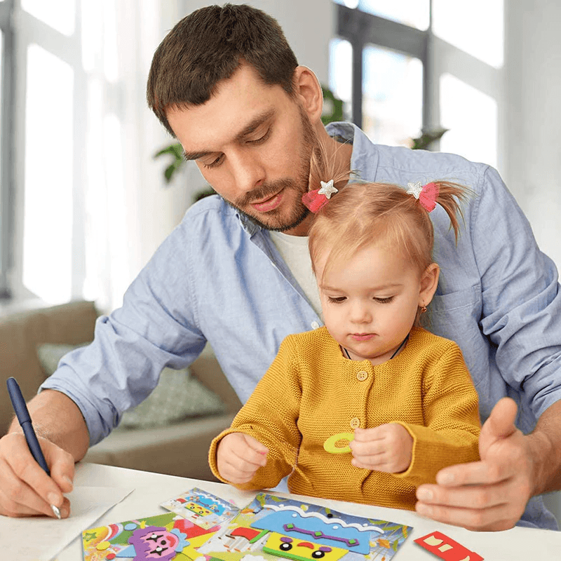 Man and child sitting at a table with sticker puzzle books, engaged in an activity.