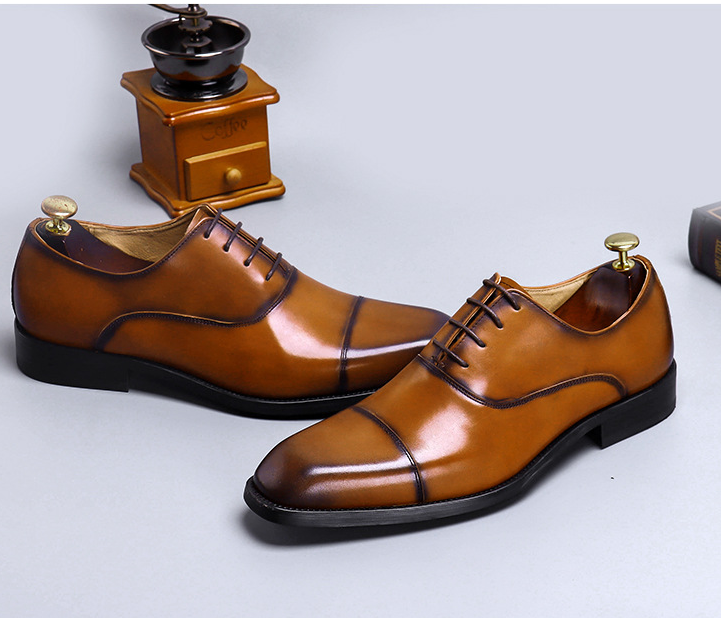 Pair of brown leather dress shoes on a light gray background