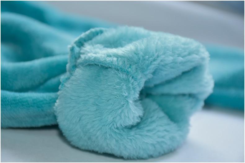 Turquoise fleece blanket on a gray surface