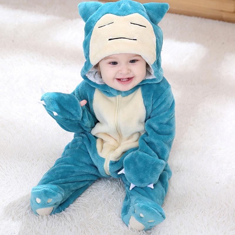 Child wearing a blue and white cartoon character onesie on a white surface