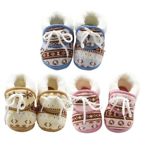 Set of baby shoes with patterned soles and white laces on a white background