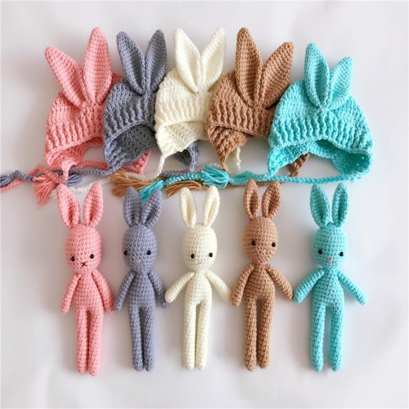 Set of colorful crochet bunny toys and hats on a white background
