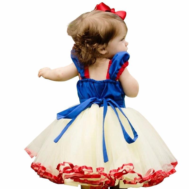 Child wearing a Snow White costume with a blue and red dress on a white background