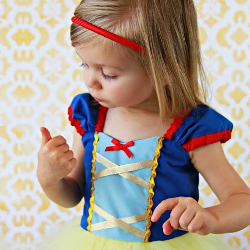 Child wearing a Snow White costume against a patterned background
