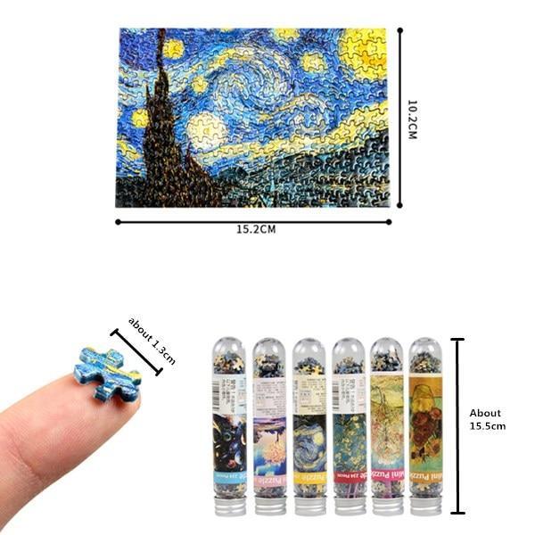 Miniature Van Gogh puzzle pieces in tubes with a small puzzle piece held by a hand, showing scale.